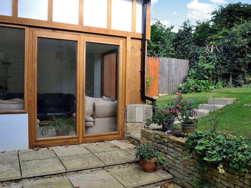 The sun room has French doors which open out to the rear garden | Orchard House, Chipping Campden