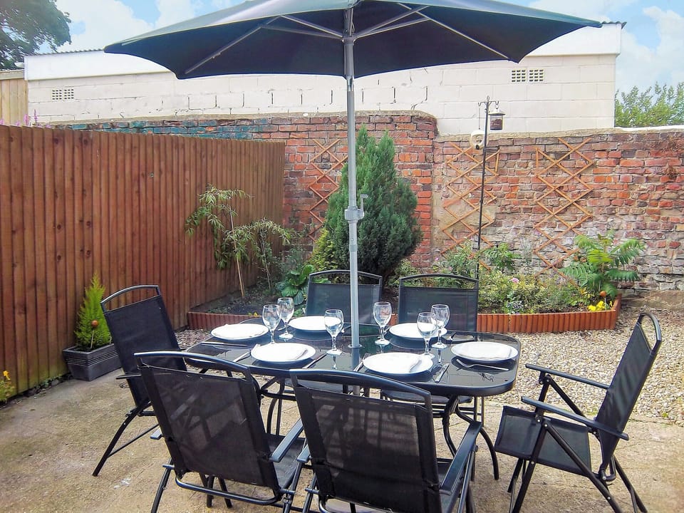 Enclosed courtyard with sitting-out area, garden furniture and barbecue | Church Court Cottage, Beeford, near Hornsea