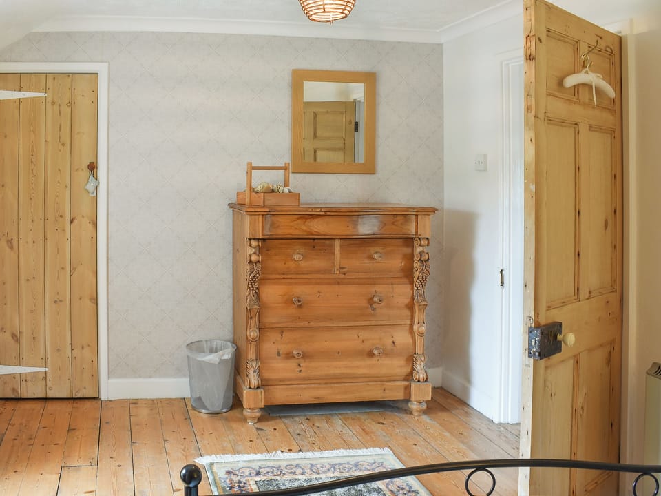 Spacious bedroom with wooden floor | Gewans Farm Cottage, Tregorrick, near St Austell