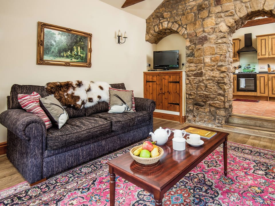 Living room with feature exposed stone wall | Cobweb Cottage - Soppit Farm Cottages, Elsdon
