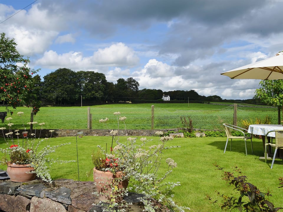 Enclosed garden boasting views over the countryside | Tre Anna Lodge, Dwyran, near Llanfairpwllgwyngyll