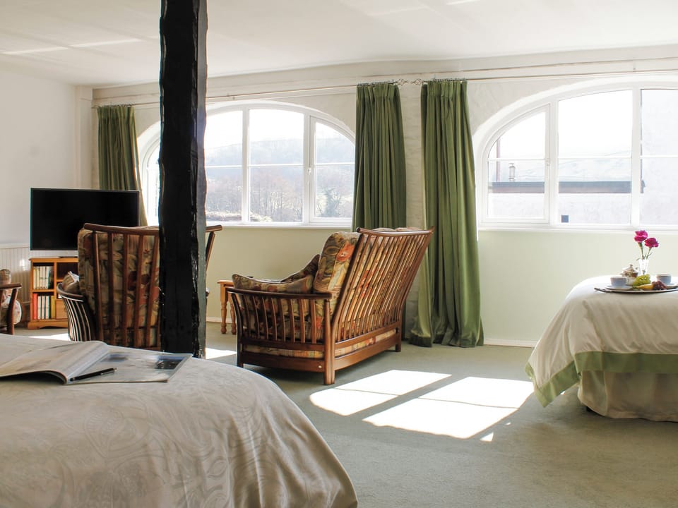 Large family bedroom with a double bed, single bed and seating area with TV | Dairy Cottage, Barnstaple