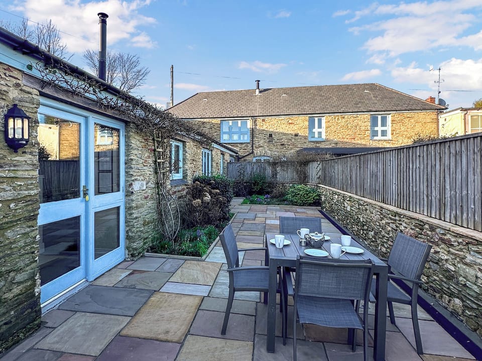 Enclosed courtyard garden with sitting-out area and garden furniture | The Hayloft, East Charleton, near Kingsbridge