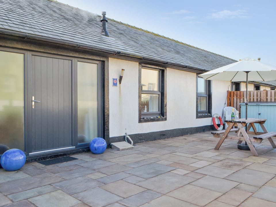 Paved patio area with outdoor furniture | Porthole Cottage, Allonby, near Maryport