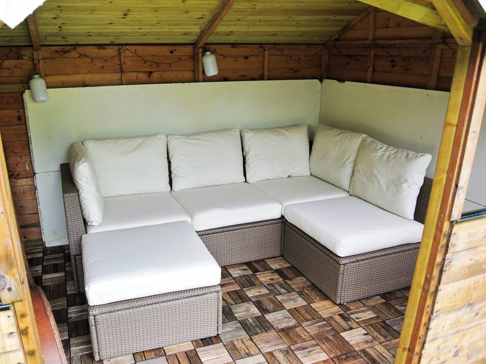 Cosy summer house with an L-shaped sofa and lights | Trevellyan Barn, St Austell