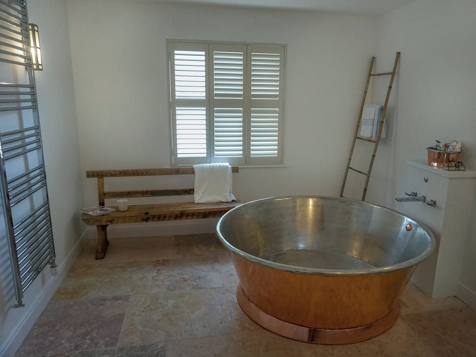Luxurious bathroom with circular, copper bath | Garden House, Thimbleby, near Northallerton