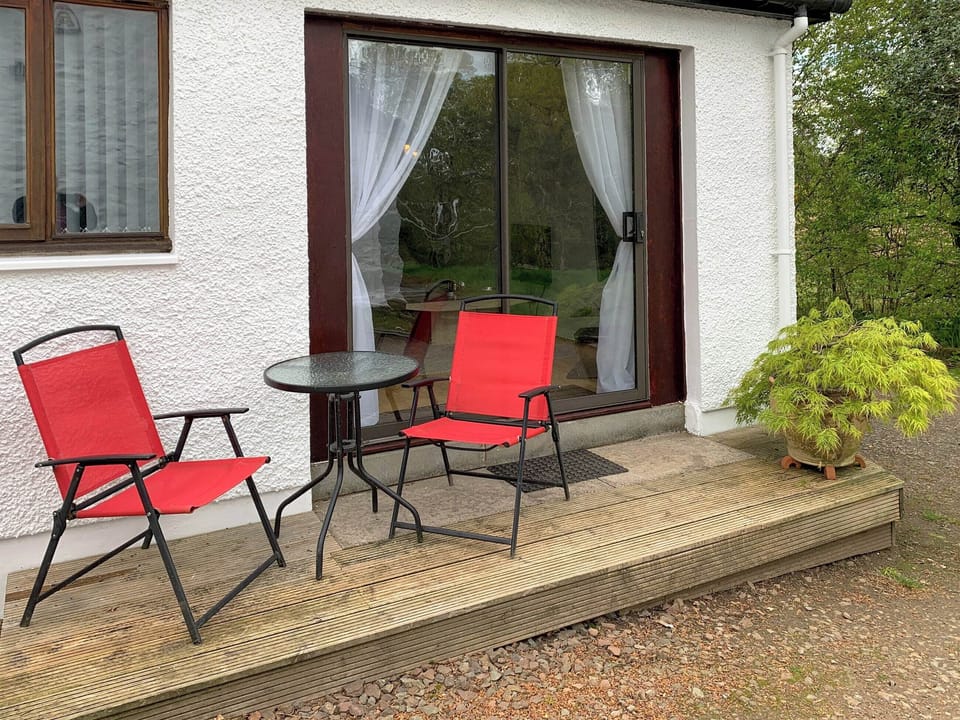 Decked patio area looking out on to unspoilt woodland grounds | Crossburn Hideaway, Arden, near Helensburgh