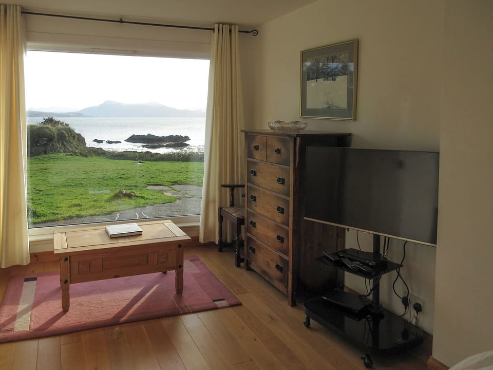 View from the ground floor en-suite bedroom with king sized bed | South Bay Cottage, Saasaig, Teangue, Isle of Skye