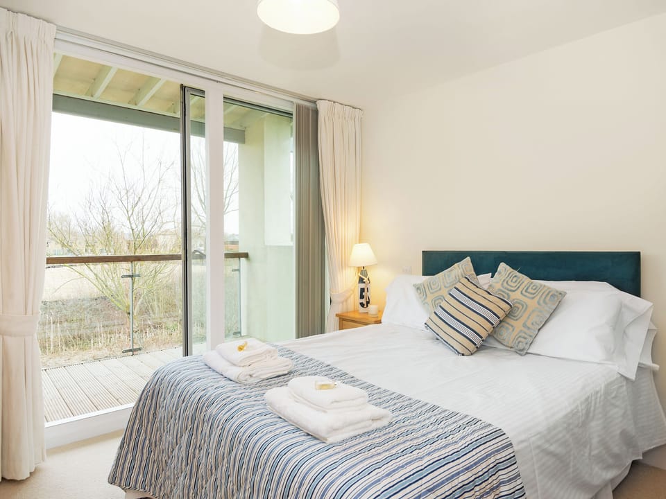 Elegant double bedroom offering views from balcony | Nuthatch, Cirencester