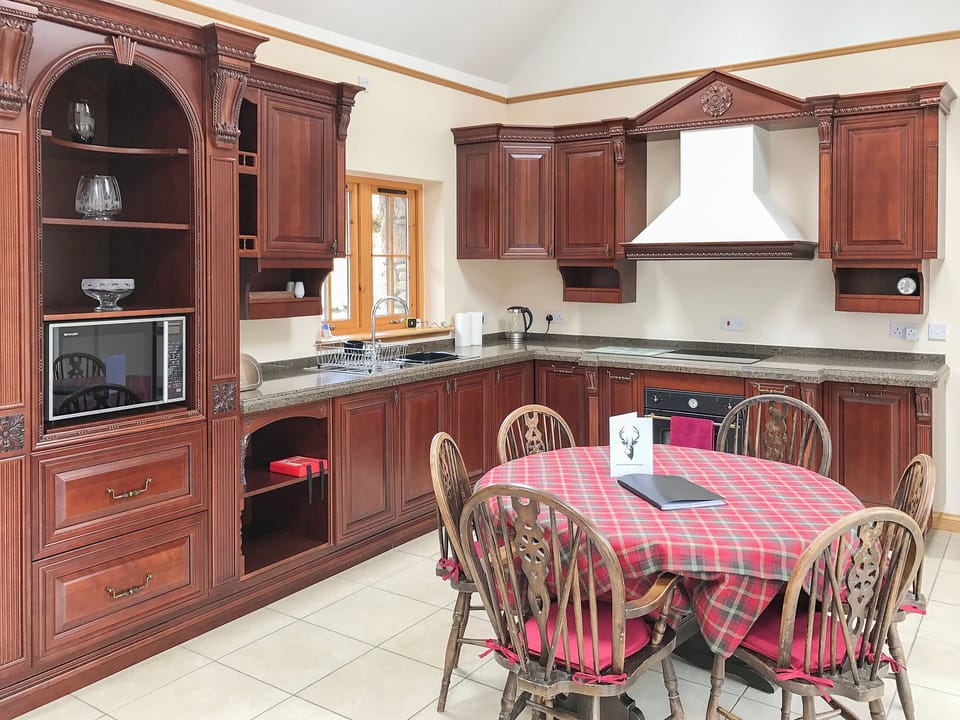 Dining area and adjacent kitchen in the open plan living area | Turin Nurin Cottage, Tomatin, near Inverness