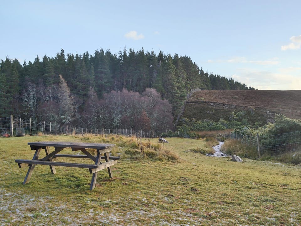 Picnic style seating in the garden with fantastic views over the surrounding countryside | Turin Nurin Cottage, Tomatin, near Inverness