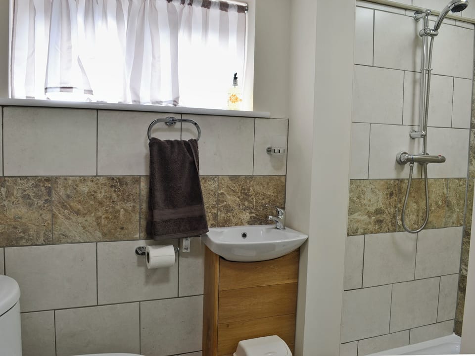 Bathroom with bath and shower cubicle | Oak House - Cysgod Y Coed Cottages, Llanrhaeadr, near Denbigh