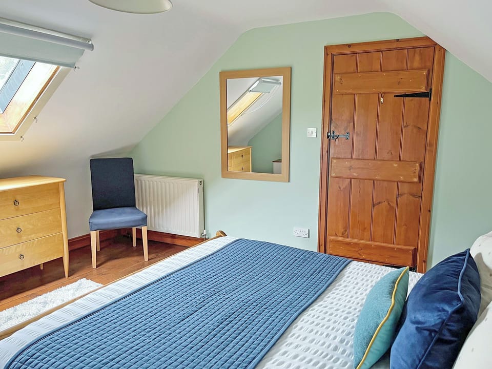 Double bedroom (upstairs) with king size wooden sleigh bed | Grange Farm Cottage, Spaunton, near Lastingham