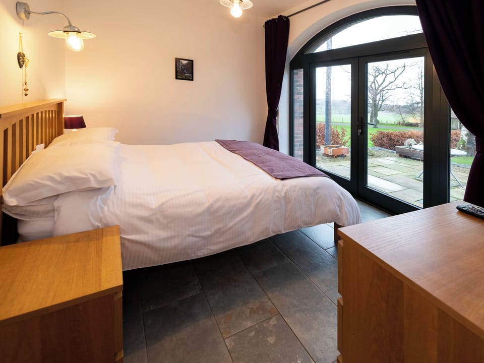 The cosy double bedroom conveniently opens up onto the patio | Cart Shed, Mauchline, near Ayr