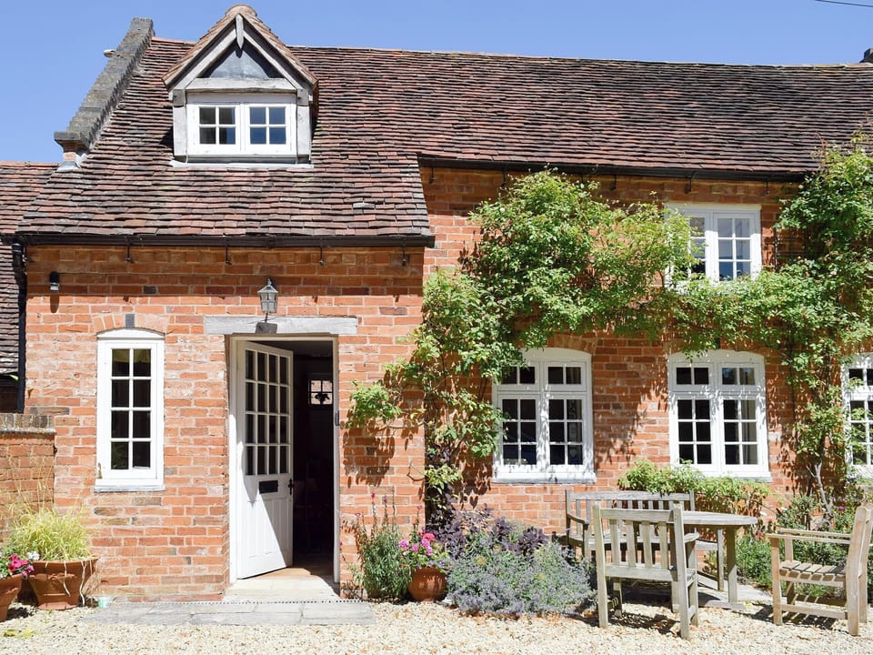 Beautiful holiday home with outdoor furniture on a gravelled patio area | The Coach House, Aston Cantlow, near Stratford