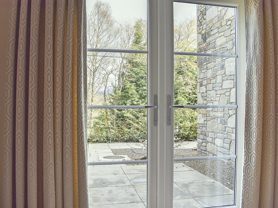 French doors open out to patio with garden furniture | Duran Holiday Cottages - Casa Duran - Duran Holiday Cottages , Killin