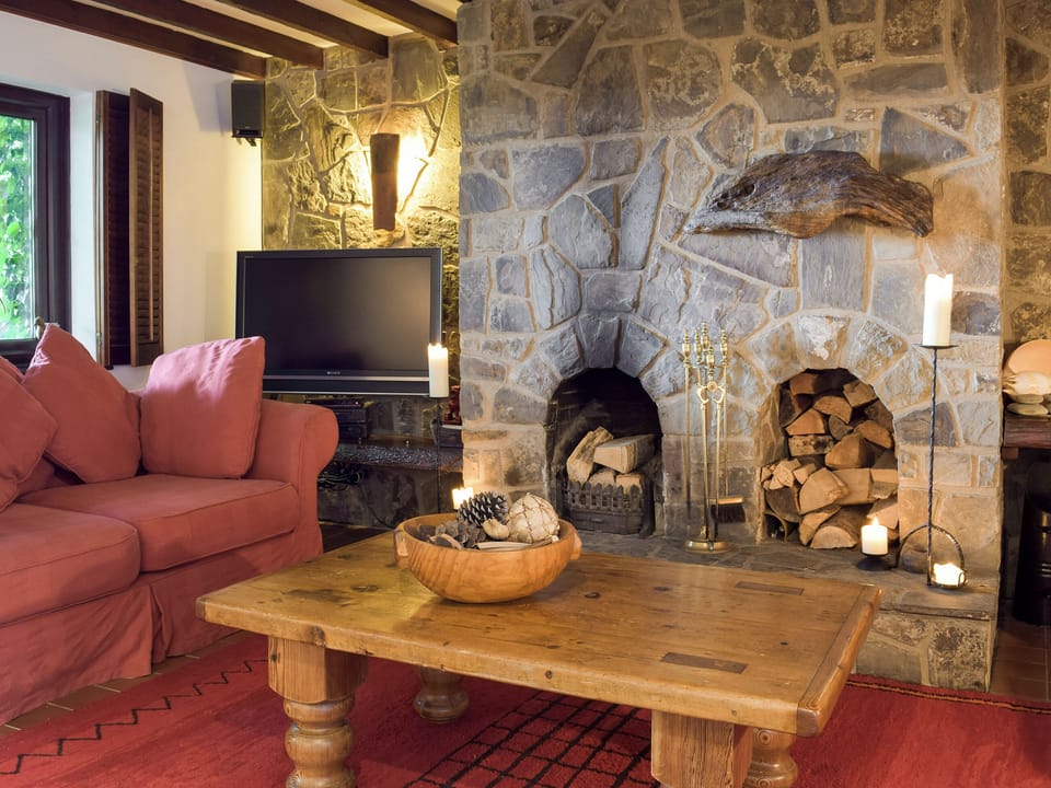 Living area with open fire and exposed stone fireplace | Sardis Cottage, near Kilgetty