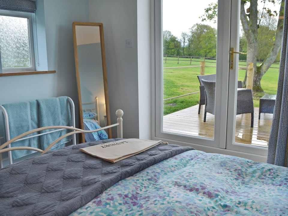 Bright and airy double bedroom with French doors leading to decked terrace | The Blue Loft, Playden, near Rye