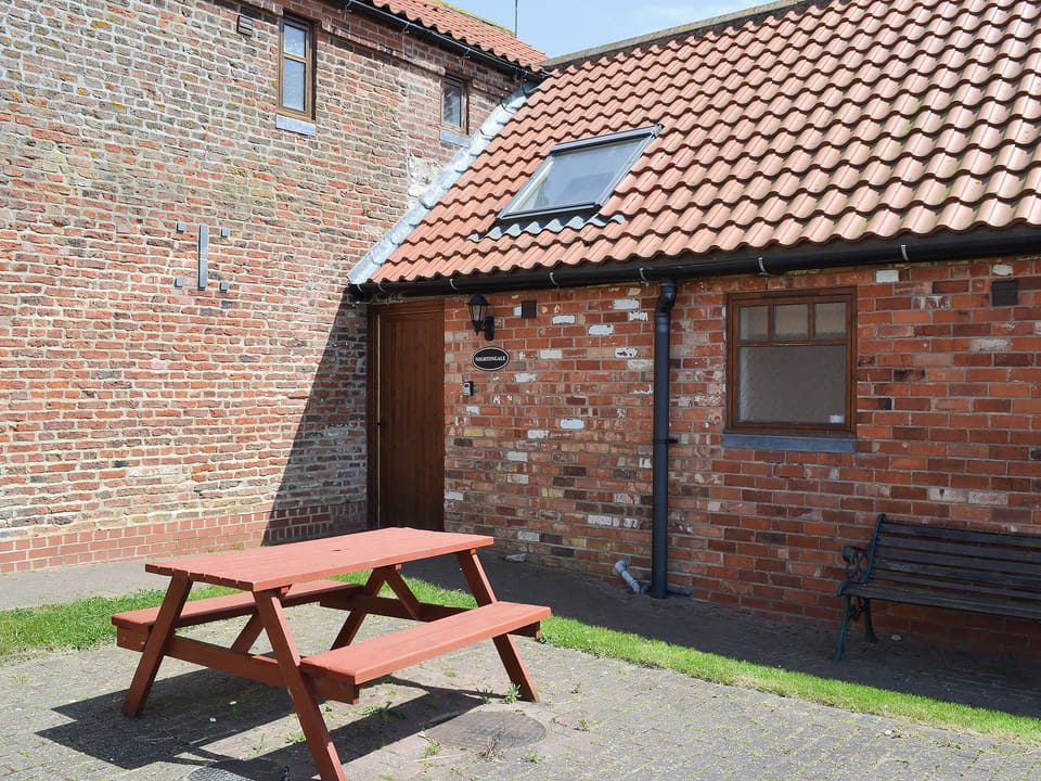 Courtyard entrance with picnic style seating | Nightingale - North Moor Farm Cottages, Flamborough