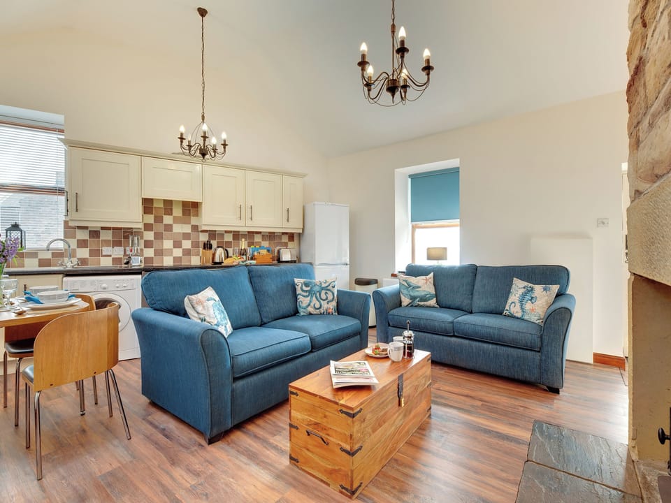 Living room area with a cosy woodburner | The Coracle, Seahouses
