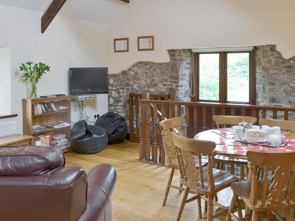 Cosy open-plan living space with wooden beams and wood floor | Homeleigh Barn - Burracott Farm, Poundstock, Bude