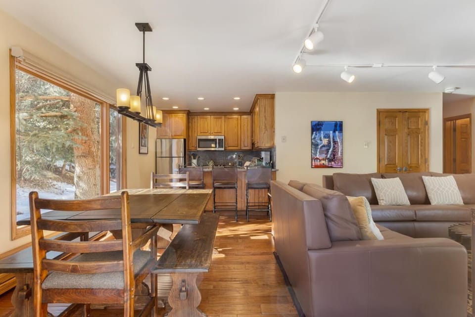 Sunlit dining and living area with rustic wooden accents