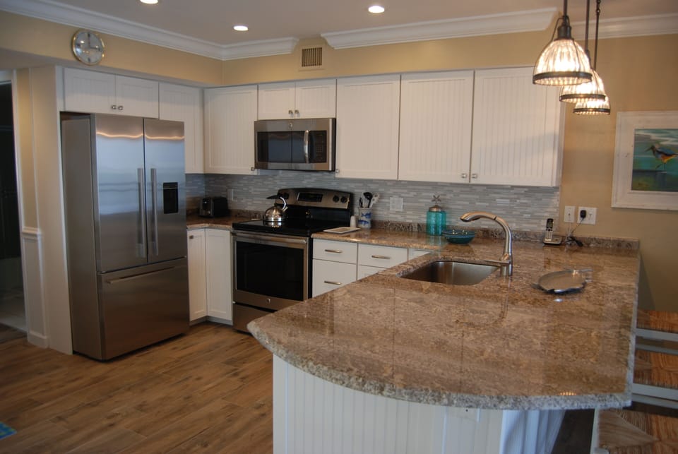 Stainless steel appliances and granite counter tops adorn the kitchen.