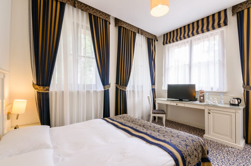 Twin Room | Minibar, in-room safe, desk, cribs/infant beds