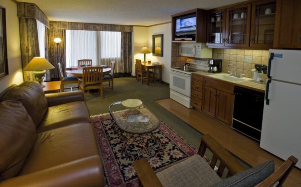 Full kitchen with sleeper sofa, dining table, hot tub on porch.