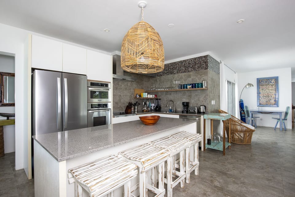 The ultra-modern kitchen features all stainless-steel appliances including French-door refrigerator, glass top range, wall oven, dishwasher, and microwave