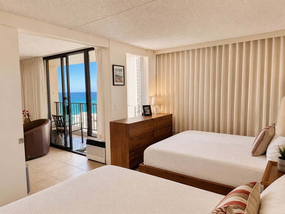 Waikiki Banyan Plumeria Suite Features two comfortable queen beds and stunning ocean views.