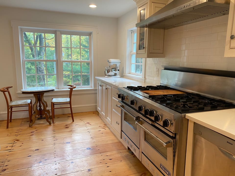 Kitchen with windows all sides and small breakfast table by the window
