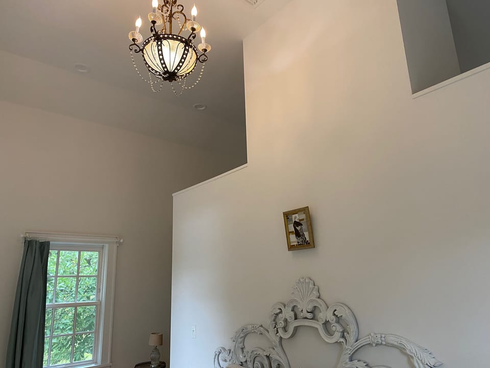 Cathedral ceiling and antique Chandelier in the master bedroom