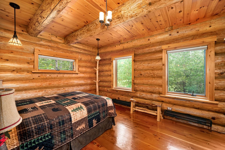 Main floor bedroom with queen bed and wooded view.