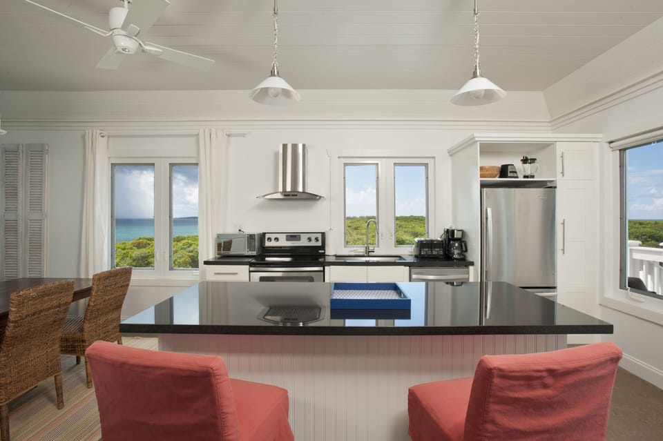 Modern kitchen in black granite and stainless steel, with views of both oceans.