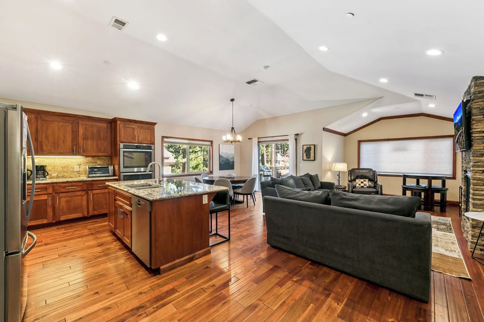 You'll love gathering in this open-concept space where rich hardwood floors flow between the gourmet kitchen and cozy living area.
