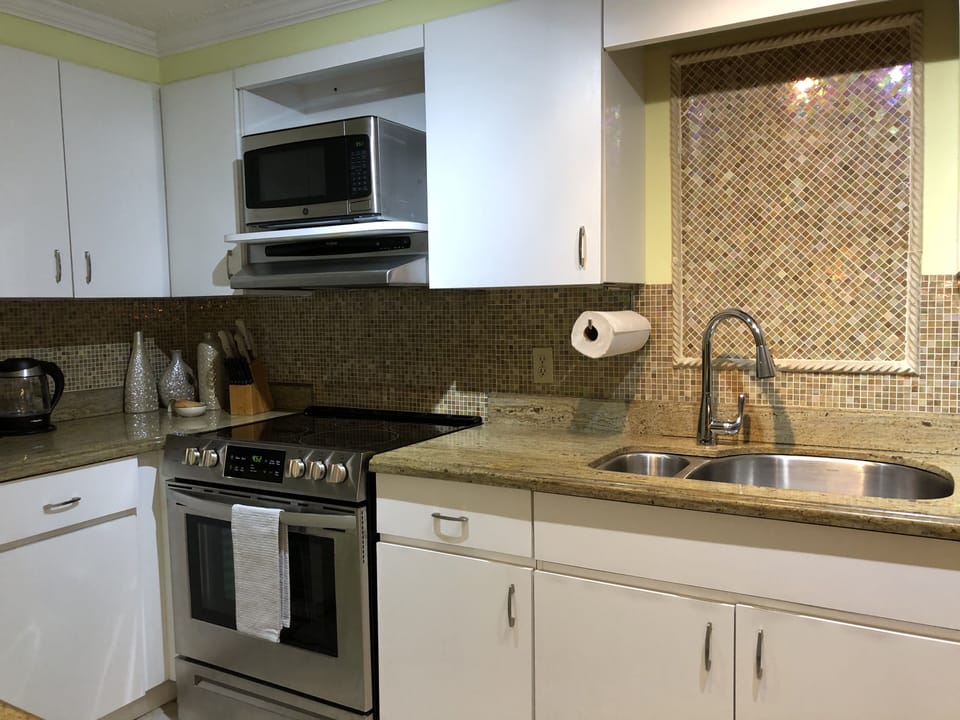Beautiful glass mosaic tiling in kitchen. New stainless appliances, double sink