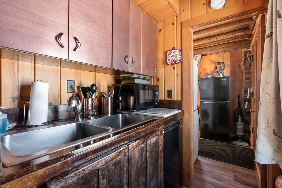 Efficiency meets elegance in the kitchen area, where a sleek sink, well-organized cabinets, and a stylish fridge in the background create a seamless culinary space for your convenience.