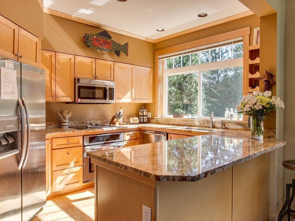 Light-filled fully stocked kitchen with stove top, oven, microwave & dishwasher.