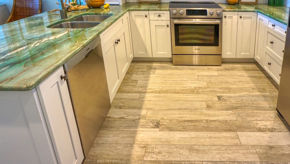 The gorgeous kitchen from the counter down shows the wood look tiles, stainless steel appliances, plenty of cabinets and that unbelievable piece of stone countertop!