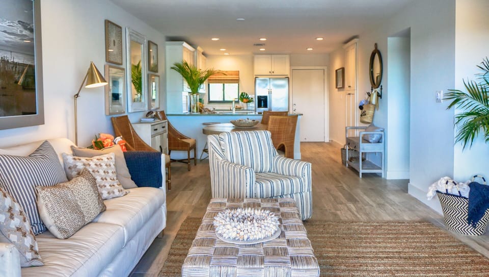You're viewing the living room through to the front entry door and kitchen from the balcony doorway in this photo.