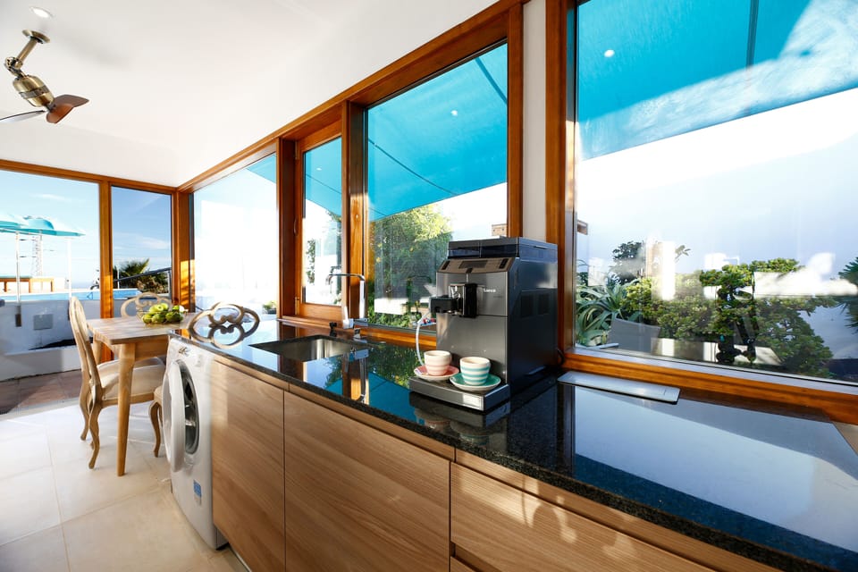full kitchen and dining area views of the sea, pool, and garden