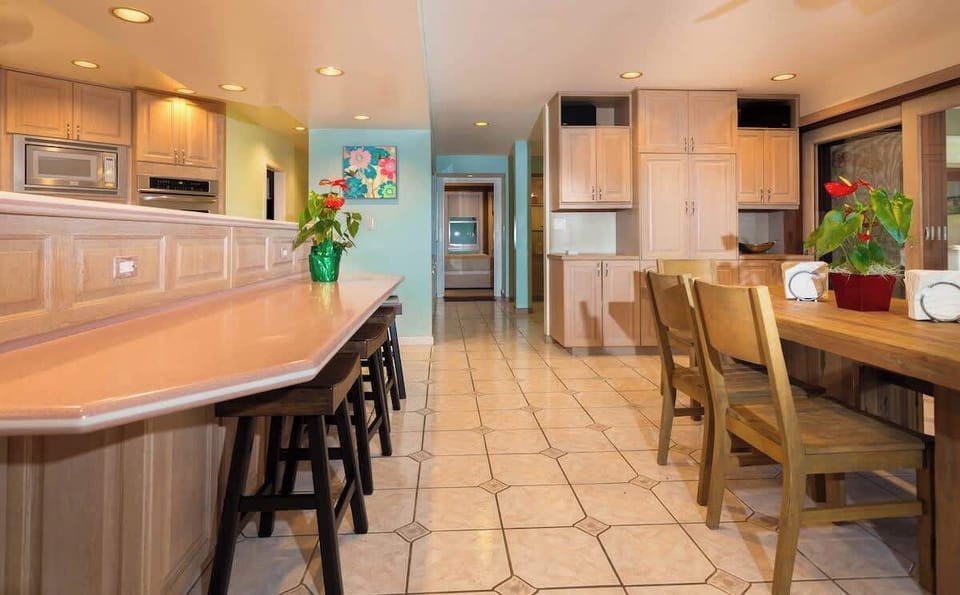 View of kitchen bar, hallway, and dining area