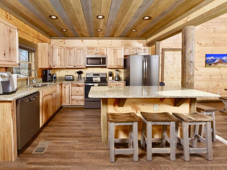 The fully-equipped kitchen has slate appliances and a large island with 4 stools.