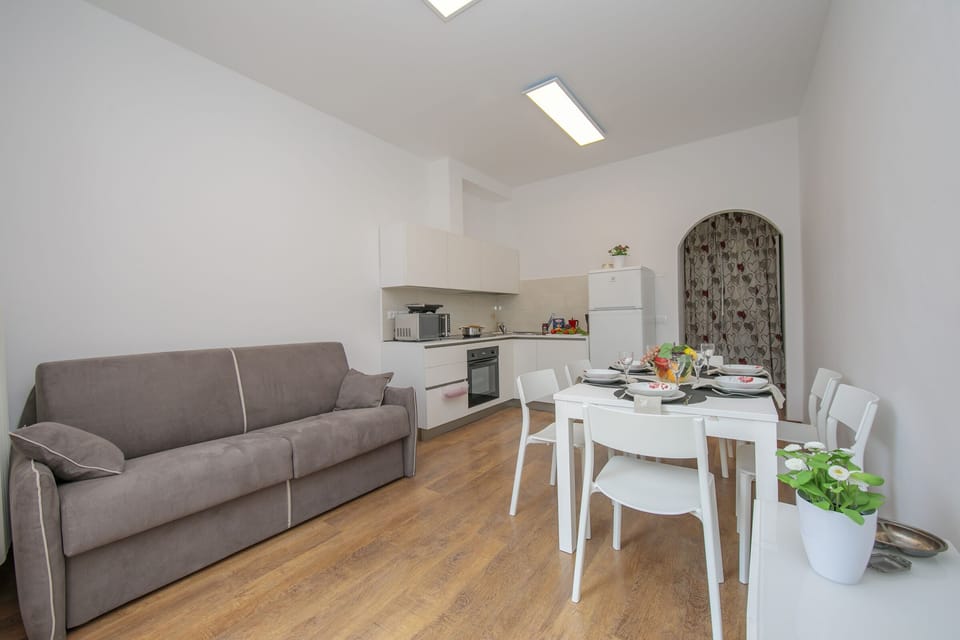 The living room with sofa, dinner table and the kitchen