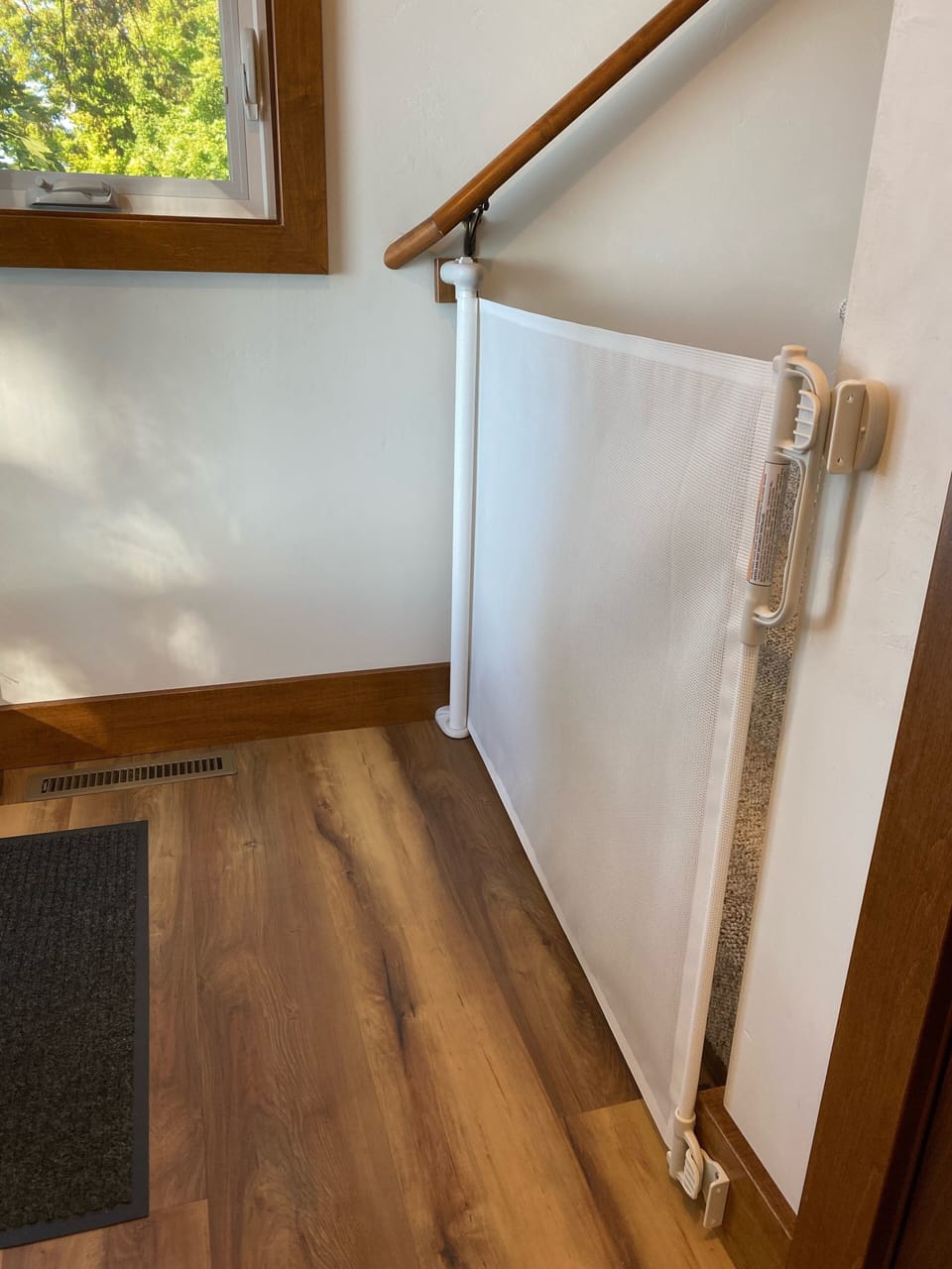 Retractable baby gate at bottom of stairs. 