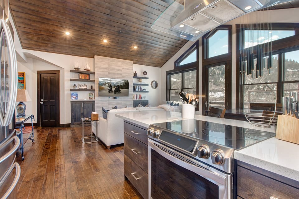 Fully Equipped Kitchen with Stainless Steel Appliances, including an Induction Electric Range, Quartz Counters and Bar Seating for Two