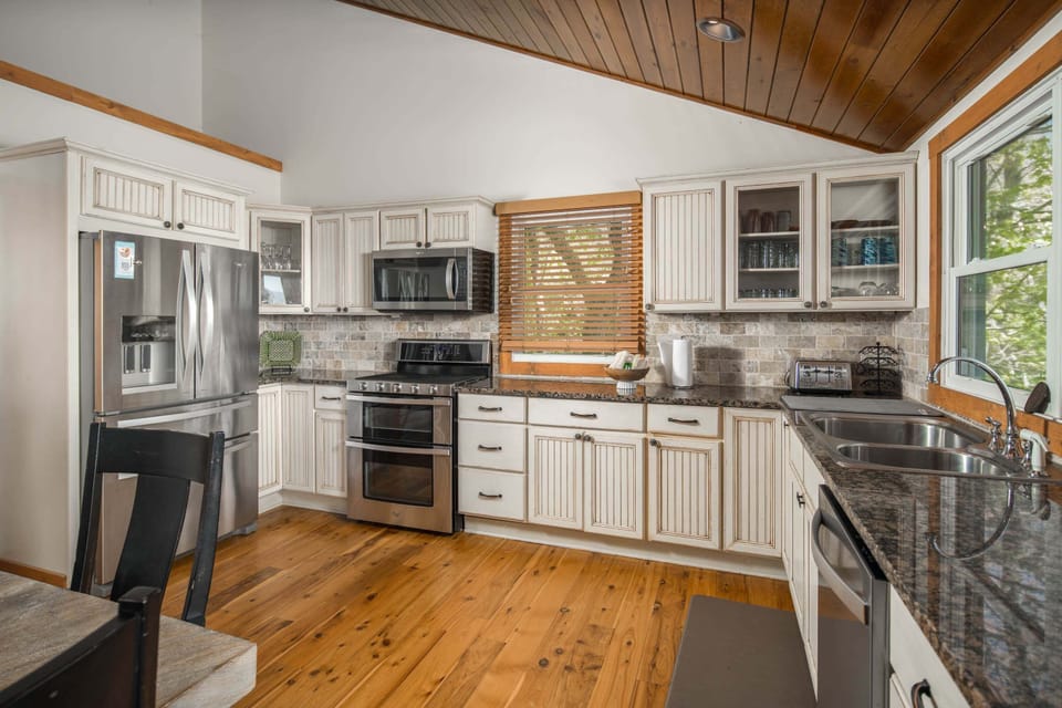Fully equipped kitchen with modern appliances, spacious counters, and mountain cabin style