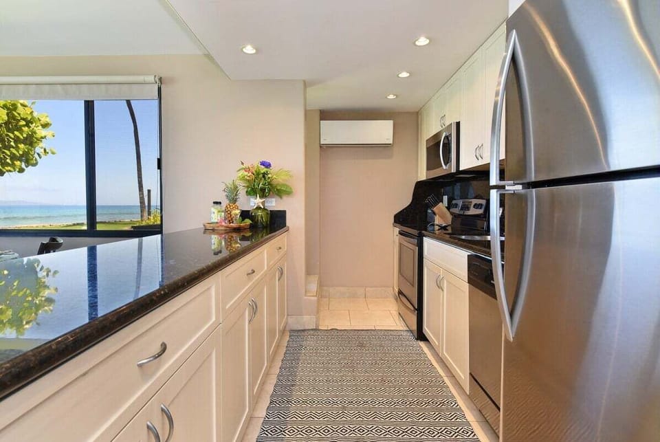 Fully equipped culinary space with bright cabinetry and a view that makes cooking a joy.
