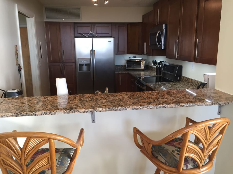 Breakfast bar and two rotating stools looking into the newly remodeled kitchen 